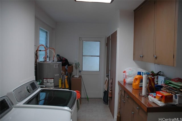 laundry room featuring cabinets, washer and clothes dryer, and water heater