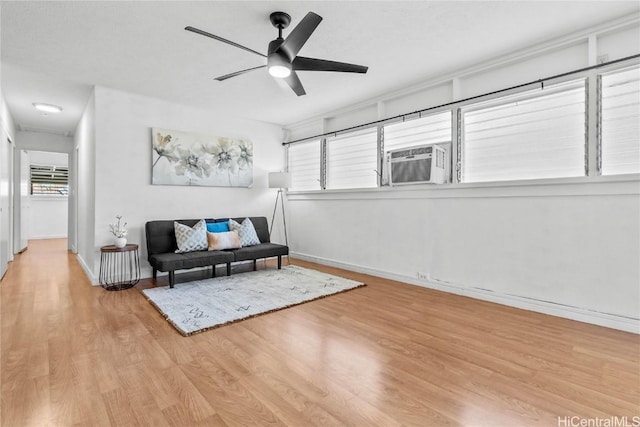 living area featuring light hardwood / wood-style flooring, cooling unit, a wealth of natural light, and ceiling fan