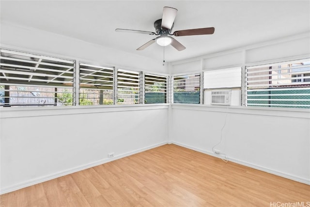 spare room featuring cooling unit, ceiling fan, and light hardwood / wood-style floors