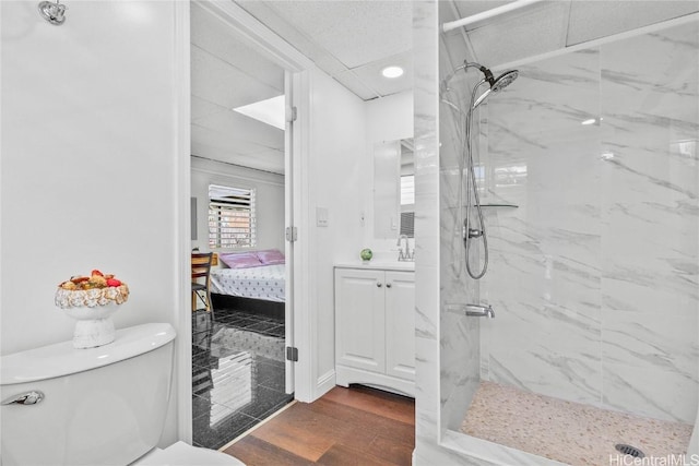 bathroom featuring vanity, tiled shower, and toilet