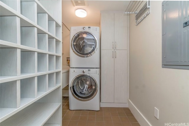 laundry area featuring stacked washer and dryer and electric panel