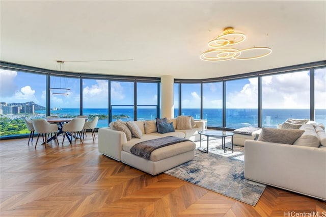 living room featuring a water view, parquet floors, and a wall of windows