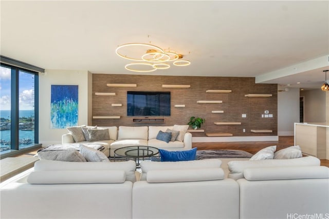 living room with floor to ceiling windows, wood-type flooring, and a notable chandelier