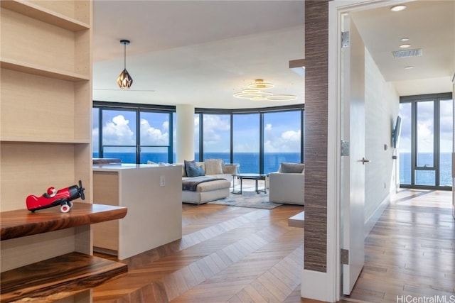 living room with light parquet flooring, a healthy amount of sunlight, and a wall of windows