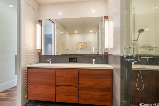 bathroom with walk in shower, vanity, tile patterned flooring, and backsplash