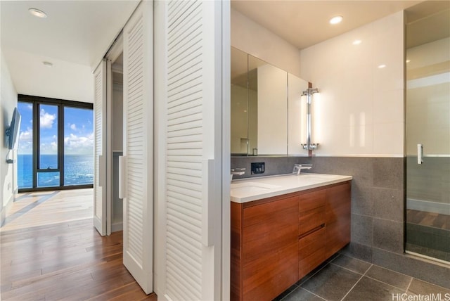 bathroom with vanity, tile patterned floors, floor to ceiling windows, and walk in shower