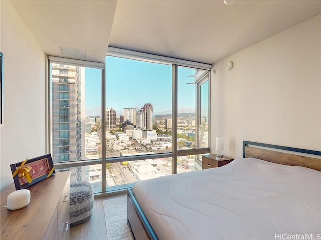 bedroom with hardwood / wood-style flooring and expansive windows