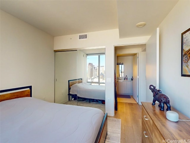 bedroom with light hardwood / wood-style flooring and a closet