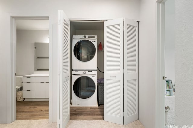 laundry room with stacked washing maching and dryer and light colored carpet