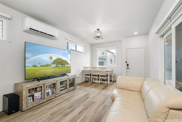 living room featuring light wood-type flooring and a wall unit AC