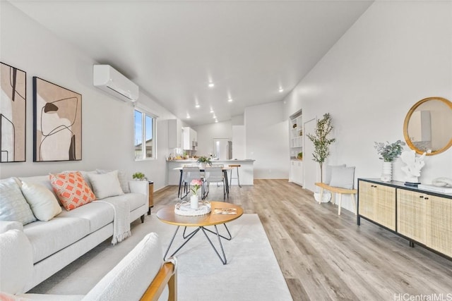 living room featuring vaulted ceiling, a wall unit AC, and light hardwood / wood-style floors