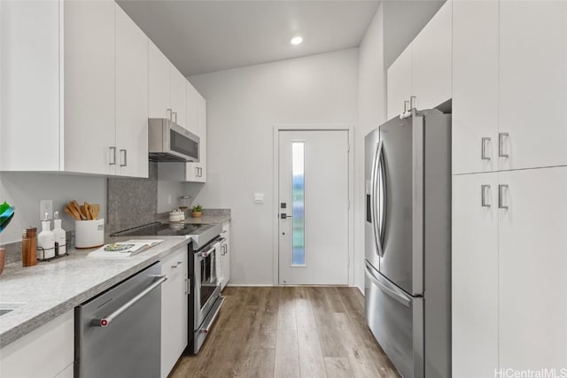 kitchen featuring stainless steel appliances, white cabinets, and light wood-type flooring