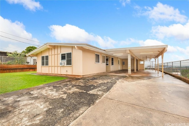 view of side of property featuring a carport and a lawn