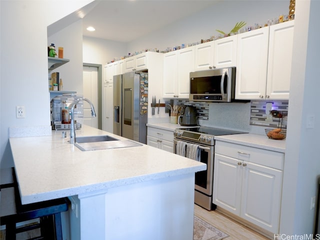 kitchen featuring tasteful backsplash, appliances with stainless steel finishes, sink, and white cabinets