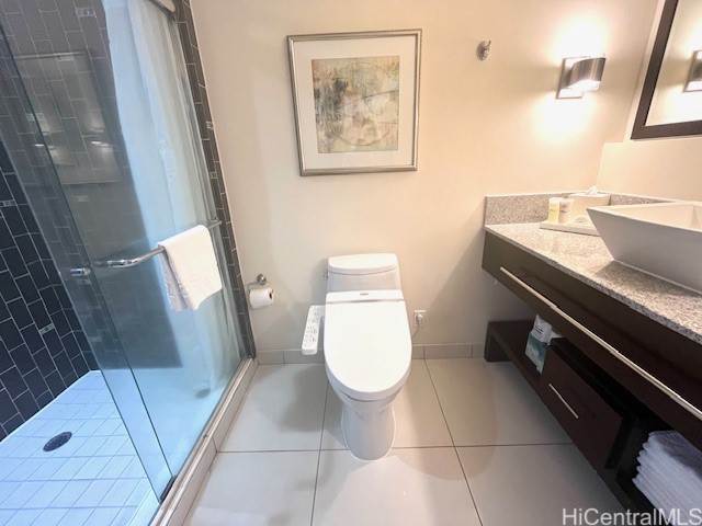 bathroom featuring tile patterned flooring, vanity, a shower with door, and toilet