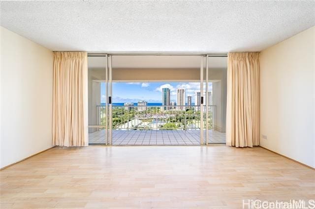 spare room with hardwood / wood-style floors and a textured ceiling