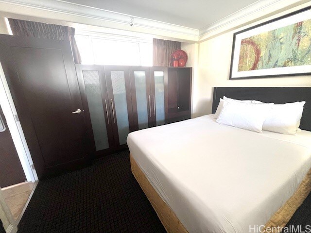 255 Beach Walk Unit 45, Honolulu, HI 96815 - bedroom featuring crown molding and dark colored carpet