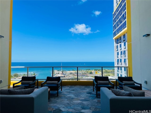 view of patio with a balcony, a water view, and a view of the beach