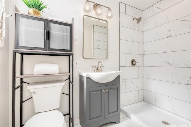 bathroom featuring vanity, toilet, and tiled shower