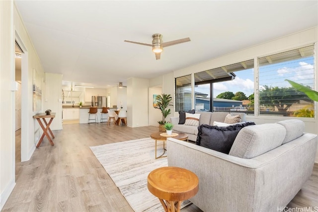 living room featuring ceiling fan and light hardwood / wood-style floors