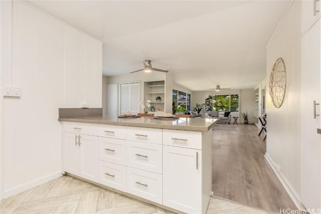 kitchen featuring white cabinetry, ceiling fan, kitchen peninsula, and light wood-type flooring