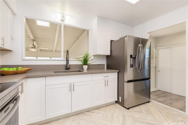 kitchen featuring sink, ceiling fan, stainless steel refrigerator with ice dispenser, white cabinets, and light parquet flooring