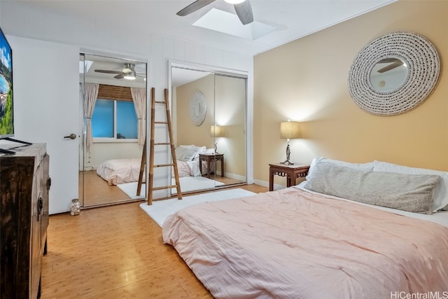 bedroom featuring ceiling fan, a skylight, and light wood-type flooring