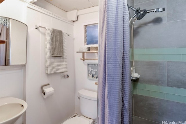 bathroom featuring sink, curtained shower, and toilet