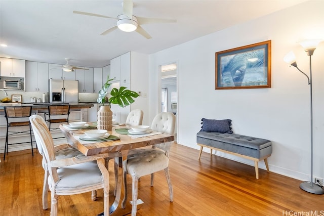 dining area featuring ceiling fan and light wood-type flooring