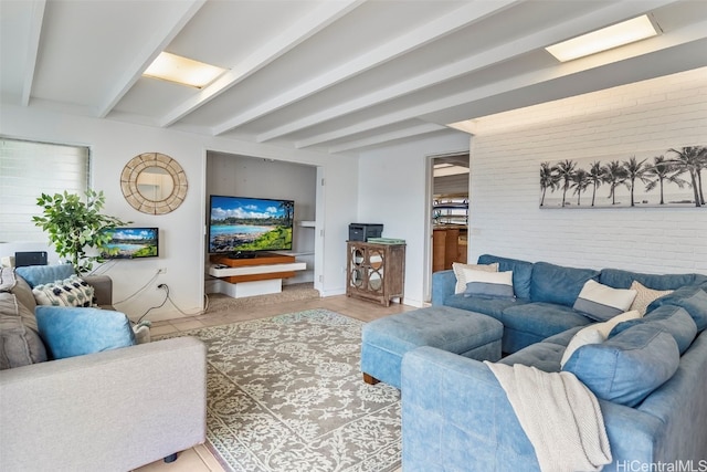 living room featuring beamed ceiling and brick wall