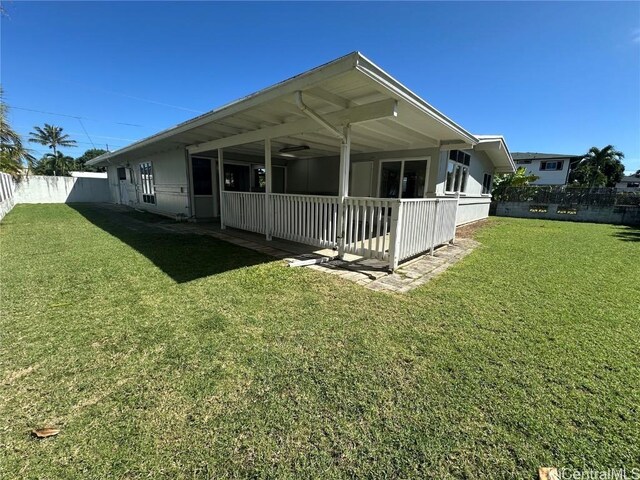 rear view of property featuring a lawn