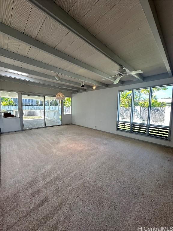 empty room with ceiling fan, beamed ceiling, and carpet