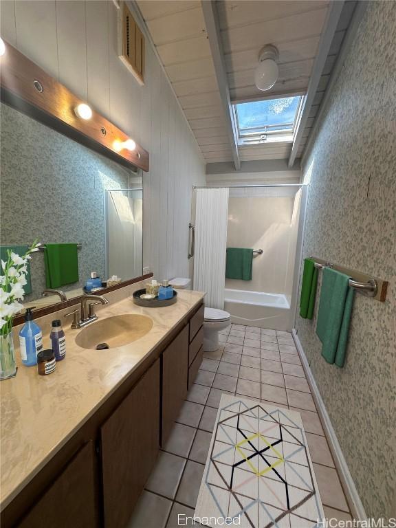 full bathroom featuring a skylight, bathtub / shower combination, vanity, toilet, and tile patterned floors