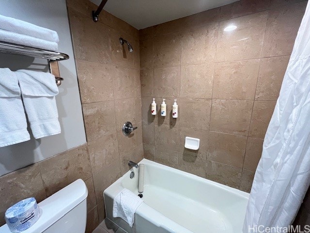 bathroom featuring shower / bath combination with curtain and toilet