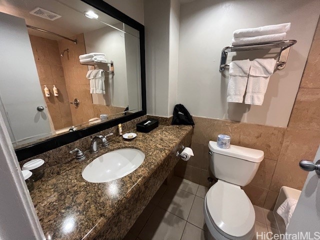 bathroom featuring sink, tile walls, tile patterned floors, toilet, and walk in shower