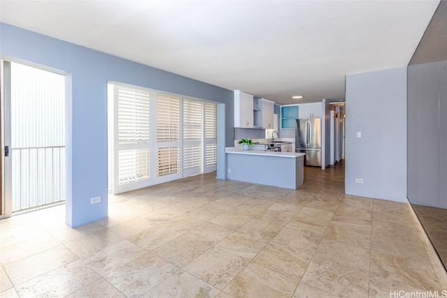 kitchen with sink, stainless steel refrigerator, and kitchen peninsula