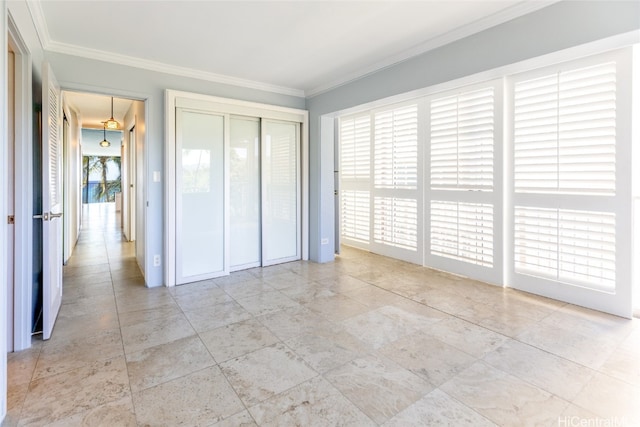 unfurnished bedroom with ornamental molding and a closet