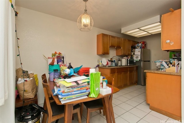 kitchen featuring light tile patterned floors, decorative light fixtures, and stainless steel appliances