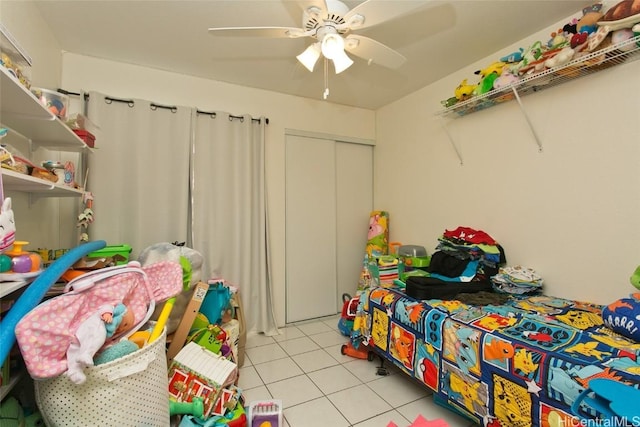 tiled bedroom featuring ceiling fan and a closet