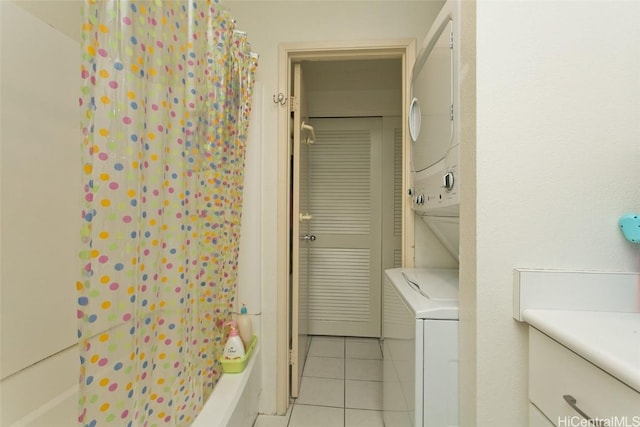 clothes washing area with stacked washing maching and dryer and light tile patterned floors