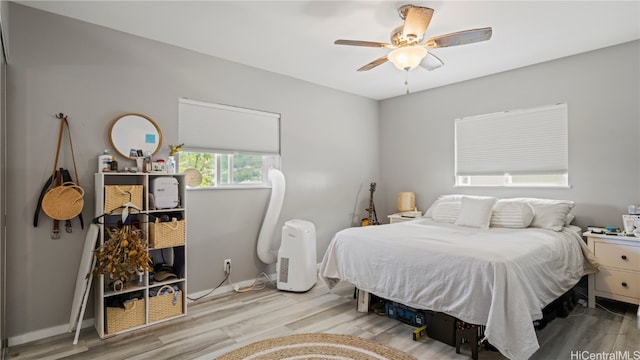 bedroom with a ceiling fan, baseboards, and wood finished floors