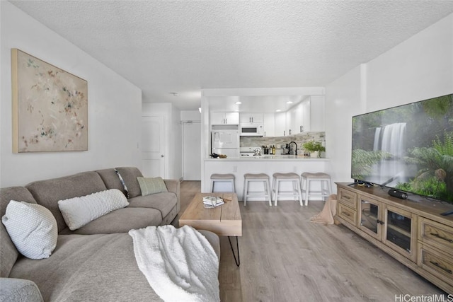 living area featuring a textured ceiling and light wood-type flooring