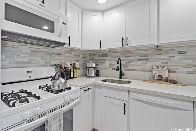 kitchen featuring light countertops, white appliances, a sink, and white cabinetry