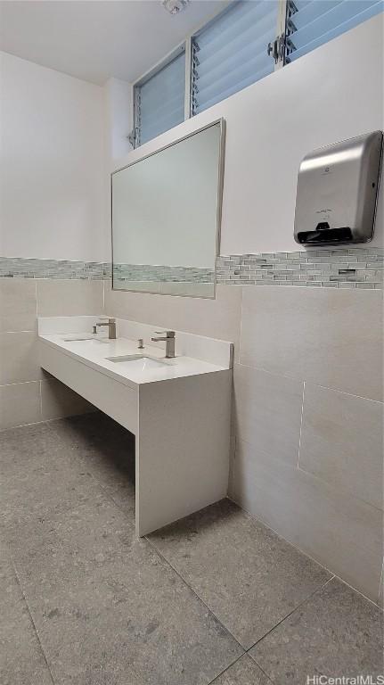 bathroom with vanity and tile walls