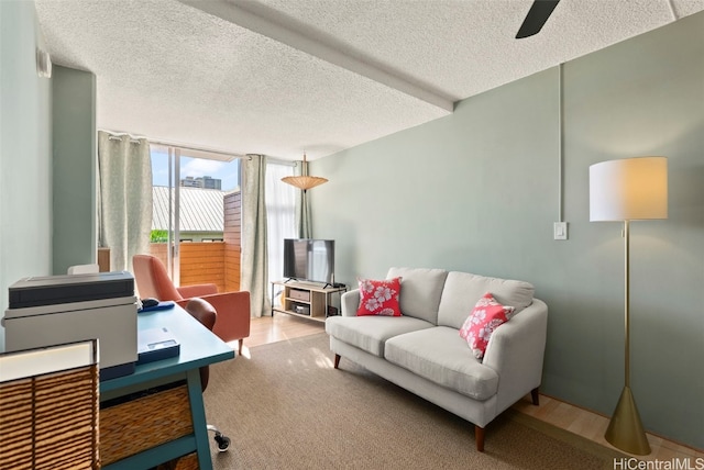 home office featuring expansive windows, ceiling fan, and a textured ceiling