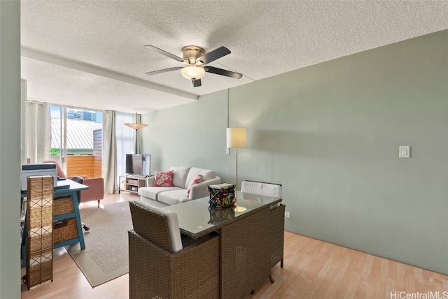 living room with floor to ceiling windows, ceiling fan, a textured ceiling, and light wood-type flooring