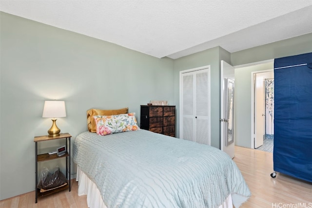 bedroom featuring a closet, a textured ceiling, and light wood-type flooring