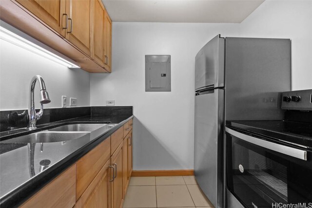 kitchen with electric stove, sink, light tile patterned floors, electric panel, and dark stone counters