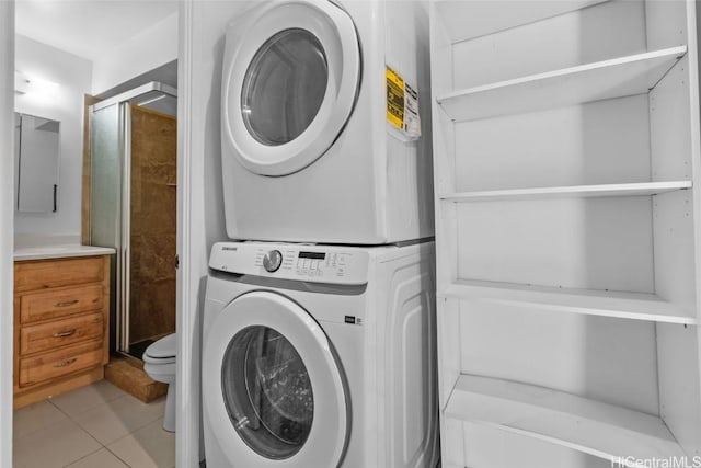 laundry room featuring stacked washing maching and dryer and light tile patterned flooring