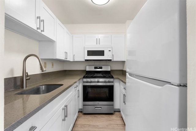 kitchen with white cabinetry, white appliances, sink, and light wood-type flooring